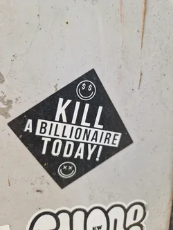 Street sticker A black diamond-shaped sticker with the text "KILL A BILLIONAIRE TODAY!" in white uppercase letters. It features a smiley face with dollar signs for eyes at the top and a similar smiley face with X's for eyes at the bottom.