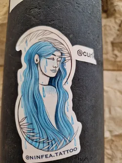 This sticker features a beautiful illustration of a woman with long, flowing blue hair.  Blue raindrops surround her, adding a sense of melancholy to the piece. The style is reminiscent of watercolor painting.  The artist's Instagram handle is visible on the sticker.