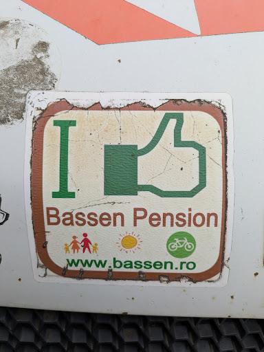 An "I Like"-themed sticker promotes Bassen Pension, featuring a green thumbs-up graphic, colorful illustrations of a family and the sun, and a bicycle icon. The website address is included at the bottom.