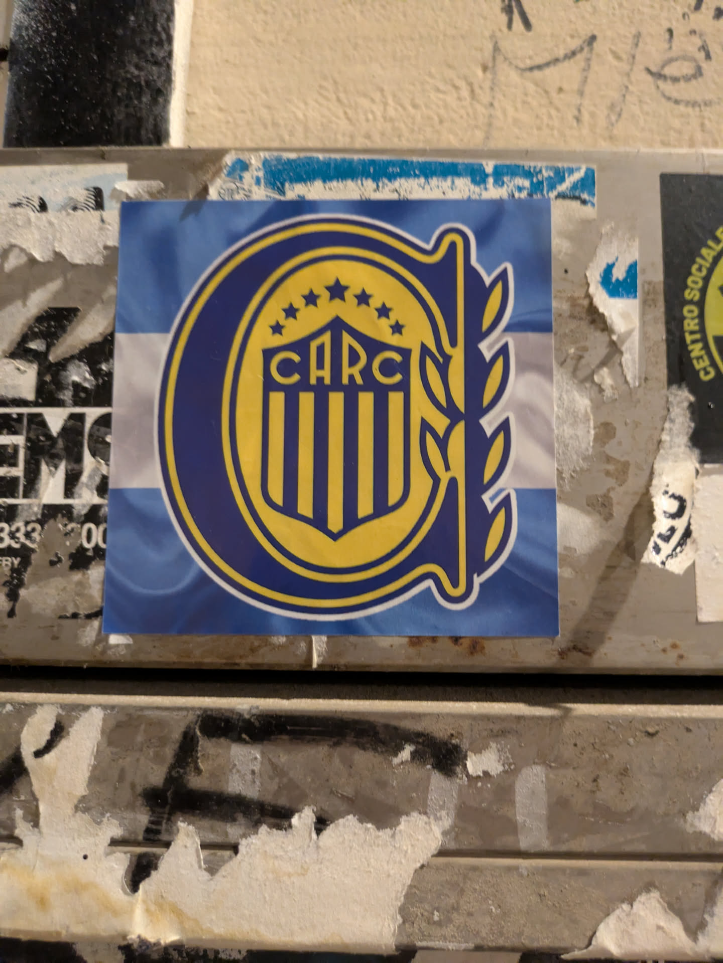The sticker features the Club Atlético Rosario Central logo, which includes a 'C' shape, laurel wreath, stars, and the abbreviation 'CARC' on a background of light blue and white.