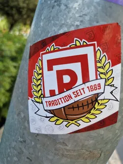 Street sticker A sticker featuring a red and white emblem with the letter R, a laurel wreath, and a rugby ball.  The text "Tradition seit 1889" is prominently displayed.