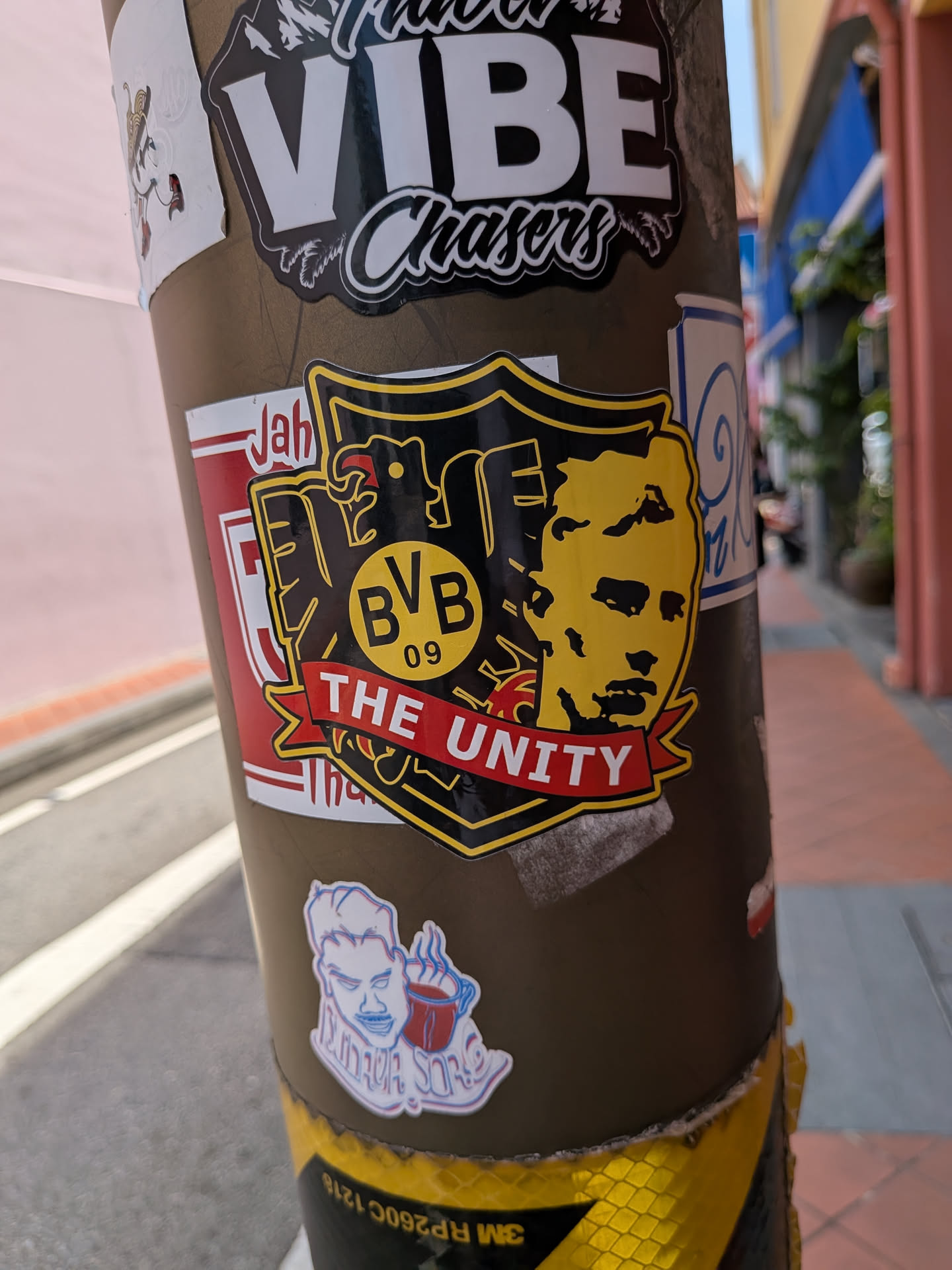 Shield-shaped sticker with a black and yellow theme. Features the BVB 09 logo, a yellow face silhouette, and a red banner reading 'THE UNITY'.