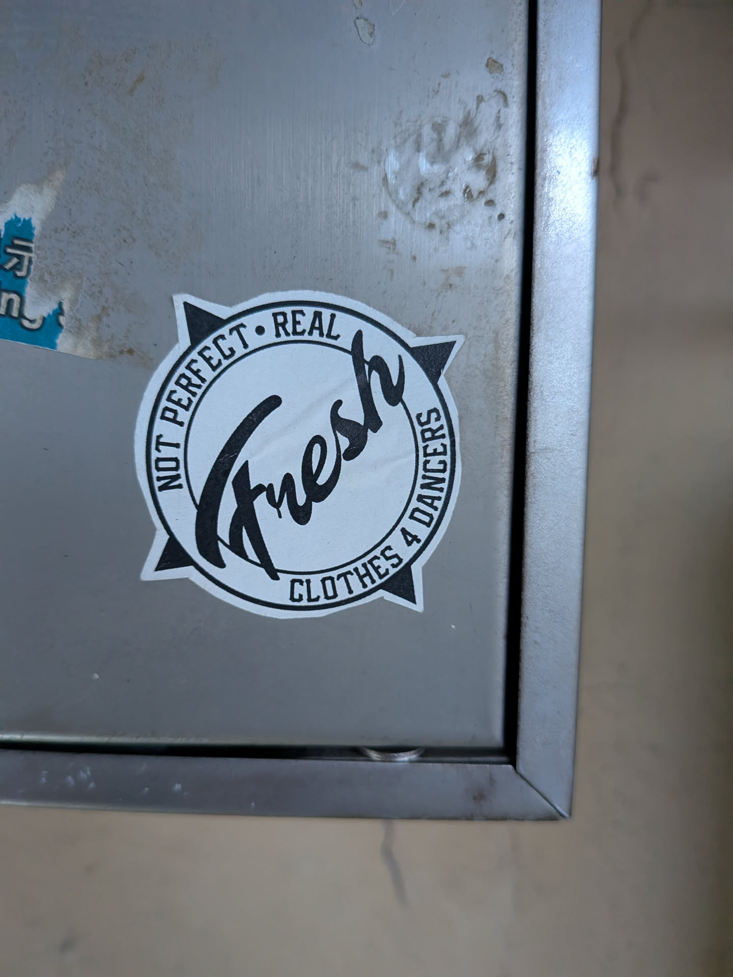 Circular black and white sticker with a compass star background. Features stylized 'Fresh' script in the center, surrounded by the text 'NOT PERFECT • REAL' and 'CLOTHES 4 DANCERS'.