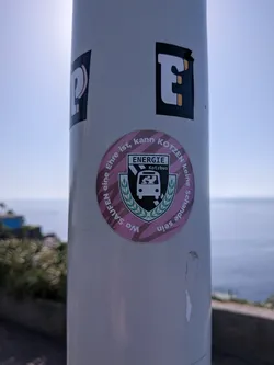 Street sticker A round pink sticker featuring a parody crest of FC Energie Cottbus, renamed 'ENERGIE Kotzbus'. The crest depicts a person vomiting from a bus, surrounded by circular German text.
