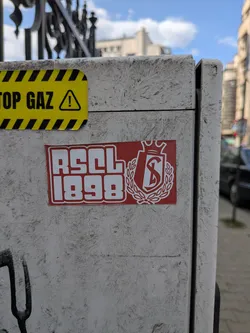 Street sticker A rectangular red sticker featuring the white bold text 'RSCL 1898' alongside the Standard de Liège club crest, which depicts a crowned shield with an 'S' enclosed in a laurel wreath.