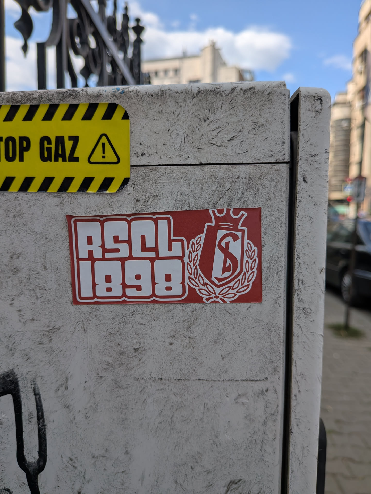 A rectangular red sticker featuring the white bold text 'RSCL 1898' alongside the Standard de Liège club crest, which depicts a crowned shield with an 'S' enclosed in a laurel wreath.