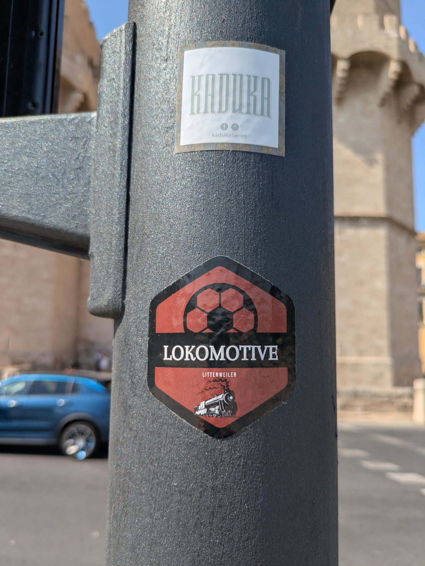 The sticker is in the shape of a shield, featuring a soccer ball at the top, the word "LOKOMOTIVE" in bold white letters across the middle, and "LITTENWEILER" in smaller white letters beneath. An illustration of a steam train is at the bottom.