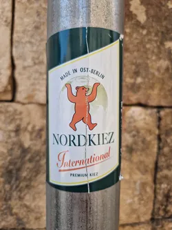 A sticker featuring a bear standing on a globe with the text Nordkiez International and Premium Kiez. The sticker also has the text Made in Ost-Berlin.