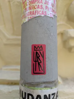 Street sticker This sticker features a red background with a black border. Inside the border, there's a simplified crown at the top and the letters 'AR' stacked vertically, also in black. The design is minimalist and graphic.