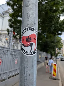 Street sticker Circular sticker with a black border reading 'EINTRACHT FRANKFURT INTERNATIONAL'. The center features a red and black waving flag with the club's eagle crest and '125 Jahre' text.