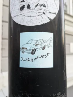 Street sticker A light blue square sticker with a black line drawing of a car and flames coming out of the exhaust. The text "Duschpalatset" is written underneath the drawing.