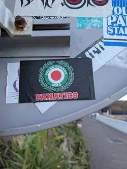 A rectangular black sticker featuring a central green, white, and red circular emblem enclosed by a green laurel wreath. The text 'VELHA GUARDA 2013' is written inside the emblem, and 'FANATICS' is printed below in red block letters with white outlines.