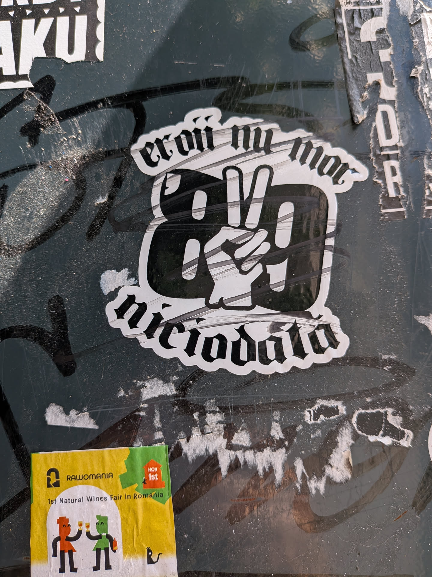 A die-cut black and white sticker featuring gothic text 'eroii nu mor' and 'niciodată'. The center shows the number '89' with a hand making a victory sign.