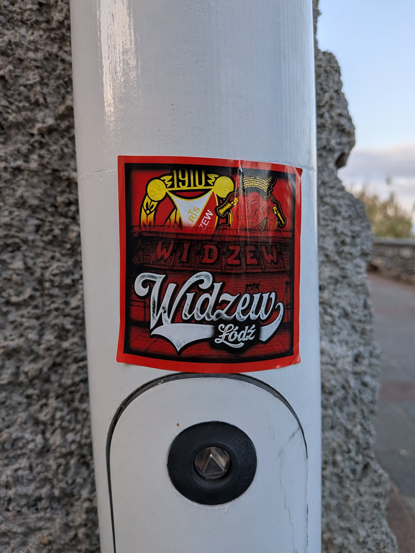 Rectangular red and black sticker representing Polish football club Widzew Łódź. Features the club crest, '1910' founding year, and the Łódź coat of arms at the top. The center depicts a stadium graphic with 'WIDZEW', and the bottom displays 'Widzew Łódź' in bold white script.