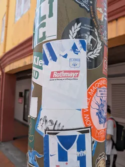 Street sticker A white, jersey-shaped sticker featuring blue shoulder details, the Puma logo, the FC Zürich crest, and the red 'Rothmayr' sponsor logo with German text underneath.