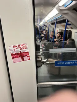 Street sticker A square sticker with a white border, predominantly featuring a two-tone red and white color scheme. The background is a lighter, faded red, depicting what appears to be a stadium or arena with floodlights. In the foreground, a dark red silhouette of a small child, seen from behind, runs towards the right. Above the child, there's a red banner with white Cyrillic text.