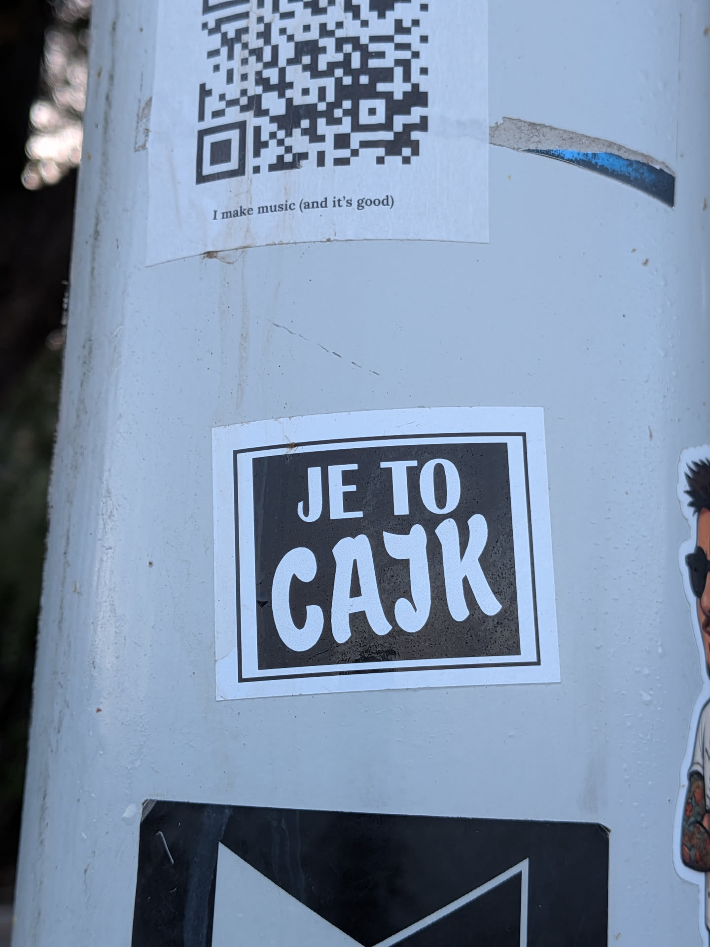 A square sticker with a black background and white border. It features the white text 'JE TO CAJK' in a bold, sans-serif typeface.