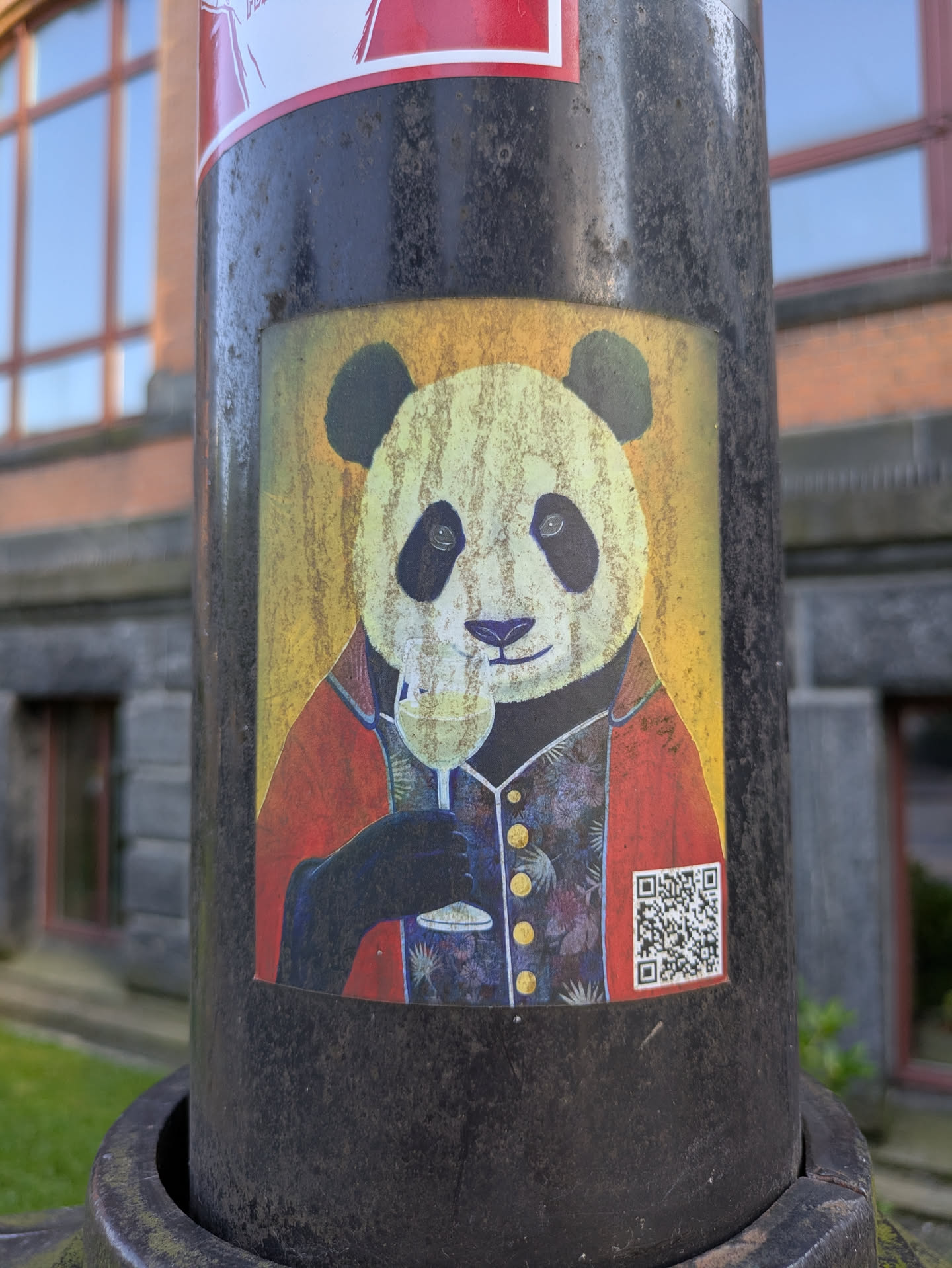 The sticker features an anthropomorphic panda, meticulously dressed in a red blazer over a dark, patterned vest with gold buttons. The panda holds a stemmed glass of white wine, appearing to take a sip or toast. The background is a textured yellow, giving the image a painted or aged appearance. In the bottom right corner, a clear QR code is visible.