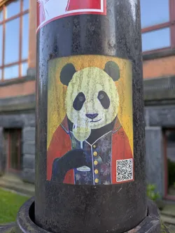 Street sticker The sticker features an anthropomorphic panda, meticulously dressed in a red blazer over a dark, patterned vest with gold buttons. The panda holds a stemmed glass of white wine, appearing to take a sip or toast. The background is a textured yellow, giving the image a painted or aged appearance. In the bottom right corner, a clear QR code is visible.