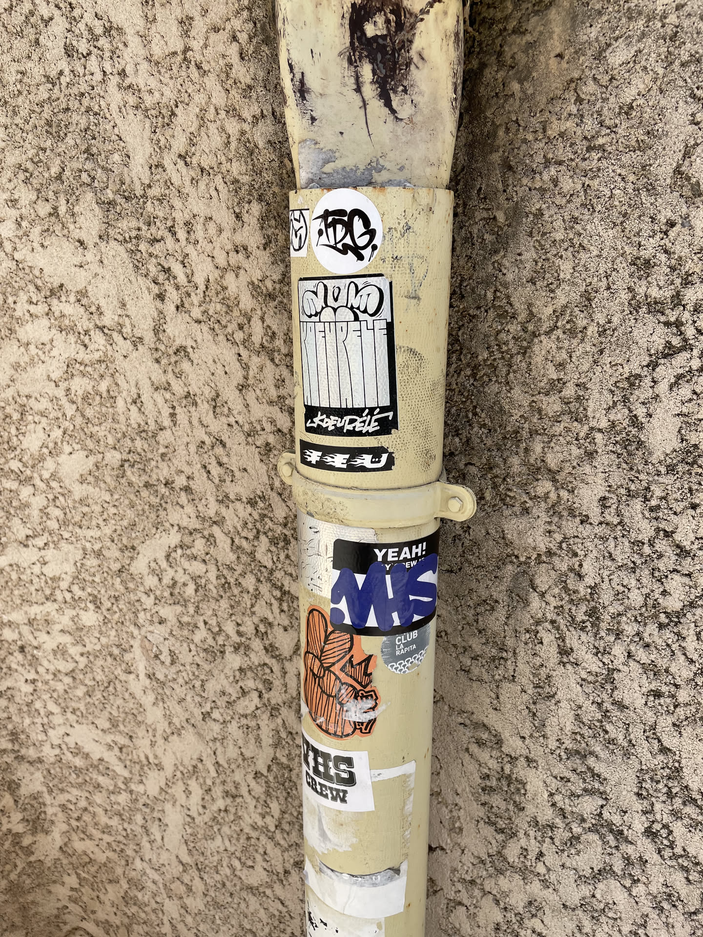 A rectangular sticker with a black border, featuring bubble letters at the top, vertical stripes in the middle, and stylized text reading 'KREUPÉLÉ' at the bottom.