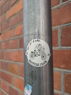 Street sticker A round sticker featuring a simple line drawing of a person riding a bicycle. The text around the illustration reads "Alltid på Våg" and "Bicycle Club", with numbers "18" and "25" on either side. The style is minimalist and slightly humorous.
