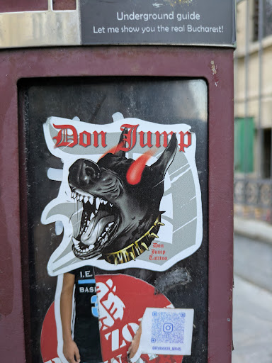 The sticker showcases a black dog with a menacing expression, sharp teeth, and red horns. The dog wears a gold spiked collar. Above the dog, the text "Don Jump" is written in a gothic font. Below the dog, it is specified "Don Jump Tattoo". There is a second sticker under the first that contains a QR code and a profile name on Instagram.
