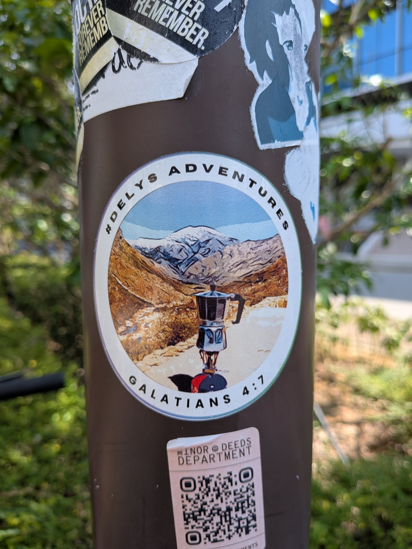 A round sticker showing a moka pot on a camp stove set against a snowy mountain backdrop. It features a white border with the text '#DELYS ADVENTURES' and 'GALATIANS 4:7'.