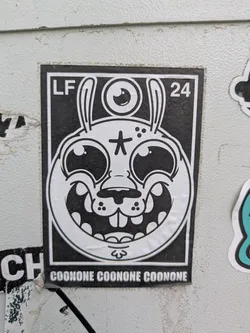 Street sticker This black and white sticker showcases a cartoonish rabbit-like creature with long ears and a single eye located above its head. The creature has a wide grin, prominent teeth, and a star symbol on its forehead. The letters "LF" and the number "24" are printed in the upper corners, and the word "COONONE" is repeated along the bottom of the sticker.