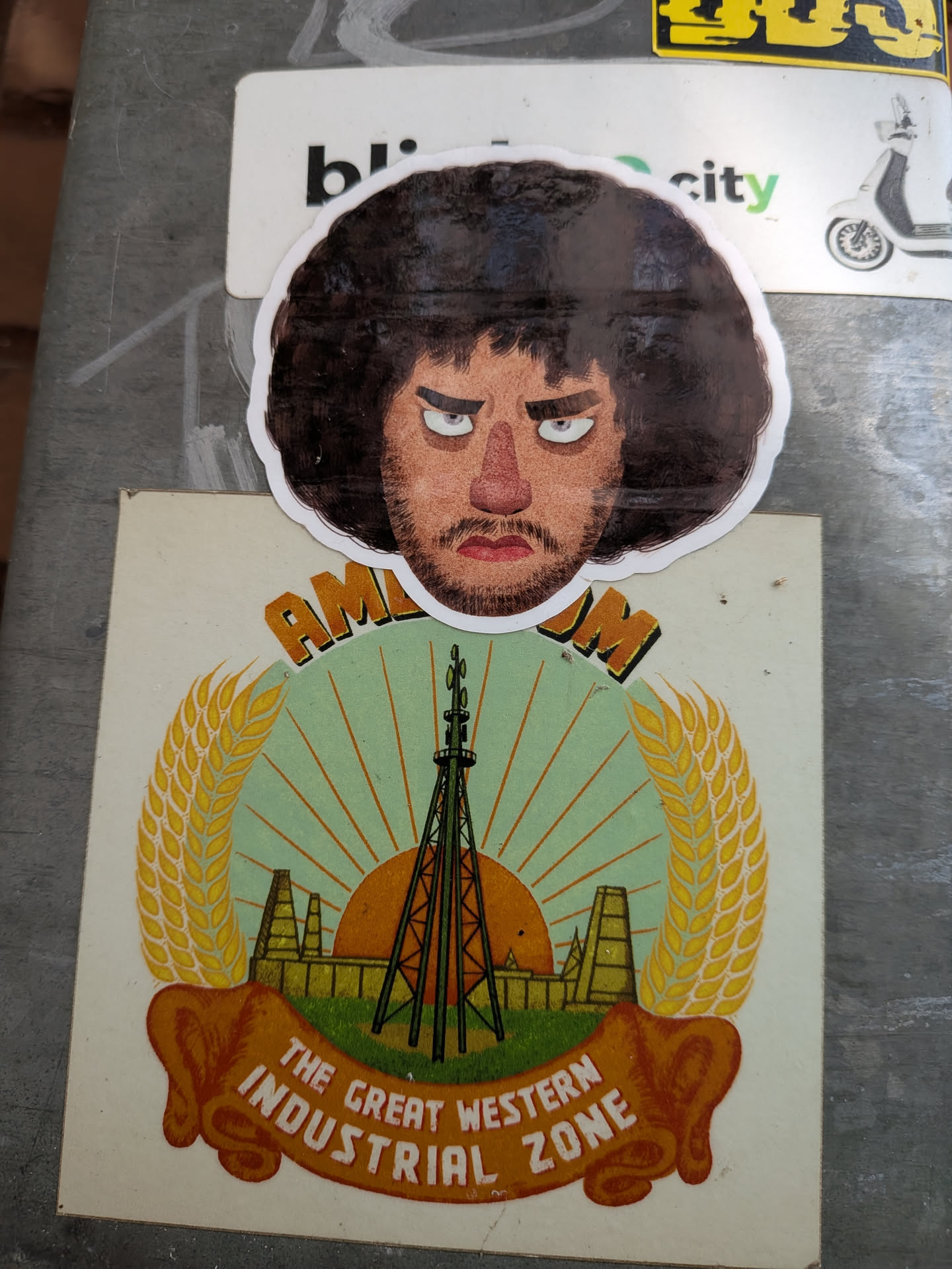 Die-cut sticker of a man's head with a large dark afro, angry expression, furrowed brows, reddish nose, and stubble, finished with a white border.