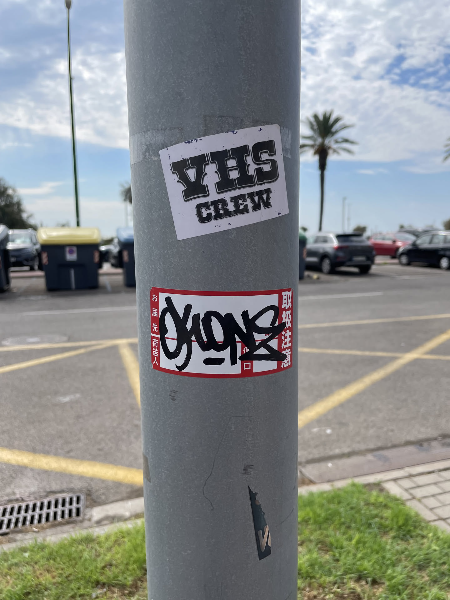 A rectangular Japanese postal label sticker with a red border and printed kanji. A bold black marker graffiti tag reading 'OKONE' is written across the center.