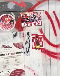 Street sticker The central sticker is rectangular, featuring a dense, stylized illustration of a crowd of figures. Many figures have their faces obscured by masks, scarves, or hoods, and some appear to be holding flags or banners. The dominant colors are red, white, and black, with some yellow accents. Below the crowd, in a bold, blocky white font with a red outline, is the Cyrillic word 'ПАНЧЕВО'. The overall appearance conveys a sense of unity, intensity, and group identity.