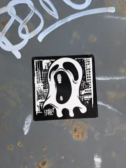 Street sticker A square black and white sticker depicting a stylized, screaming white ghost. The background features a high-contrast urban cityscape. The word 'stoker' is written in stylized script at the bottom left.