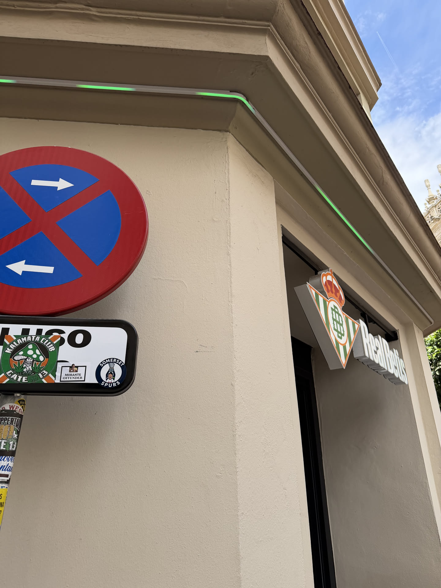 A circular sticker featuring a vibrant green background with white elements. At its center is a stylized white mushroom with green spots. Arched above the mushroom, in white capital letters, is "KALAMATA CLUB". Below the mushroom, also in white capital letters and arched, is "GATE 13". The design has the appearance of a football club's crest or a fan group's emblem, with a slightly worn texture suggesting it's a physical sticker.