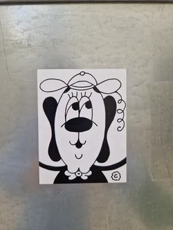 Street sticker This sticker features a charming illustration of a dog with a simplistic design. The dog is depicted wearing a hat, and its facial expression is friendly and approachable. The overall style is minimalistic yet expressive.