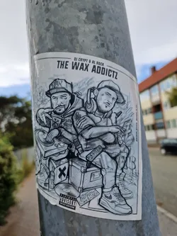 Street sticker A grayscale sticker featuring an illustration of two DJs, DJ Crypt and Al Rock, with their equipment.  The style is reminiscent of graffiti or street art.  It includes a parental advisory label.