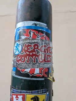 Street sticker Rectangular sticker featuring red graffiti-style 'ENERGIE COTTBUS' text over a grey brick background. Includes a blue lion emblem, regional map outline, and slogans 'STOLZ DER LAUSITZ' and 'FORZA FCE'.