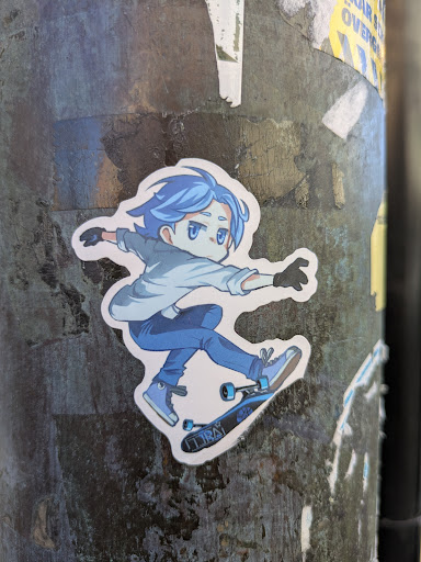 A sticker of Reki Kyan from the anime Sk8 the Infinity, he is doing a skateboarding trick. Reki is depicted with blue hair and blue clothes with matching skateboard.