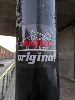 Street sticker A black and white sticker with two birds facing each other. The word "RANDOM" in red is written between the birds. Below the birds, the word "original" is written in white. The text "BASTARDS" is written in small letters under the word "RANDOM".
