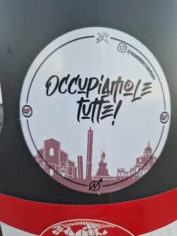 Street sticker Round sticker with the text "Occupiamo le tutte!" in a stylized font.  It also features a simple line drawing of a cityscape, possibly Palermo, and a small logo. An Instagram handle is visible in the upper right corner.