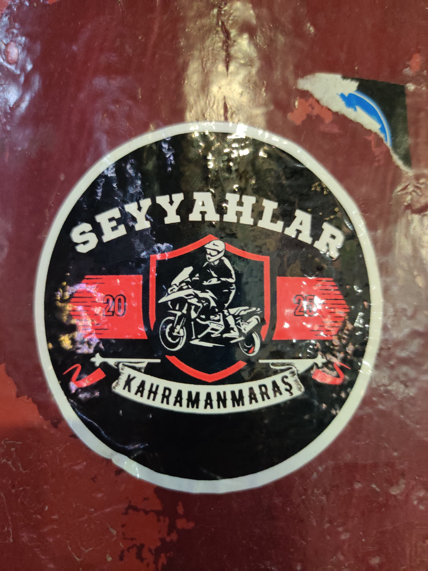 A round black sticker with a white border. It features a central red shield containing a motorcyclist illustration, flanked by red banners with the number '20'. The top text reads 'SEYYAHLAR' and the bottom banner reads 'KAHRAMANMARAŞ'.
