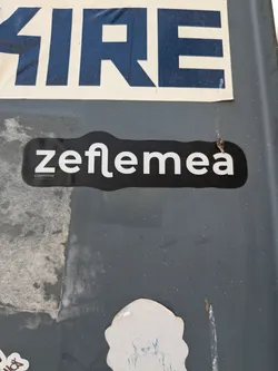 Street sticker A black die-cut sticker featuring the white stylized text 'zeflemea'. Below the 'z', smaller text reads 'cuvântor' and 'WORDROBE'.
