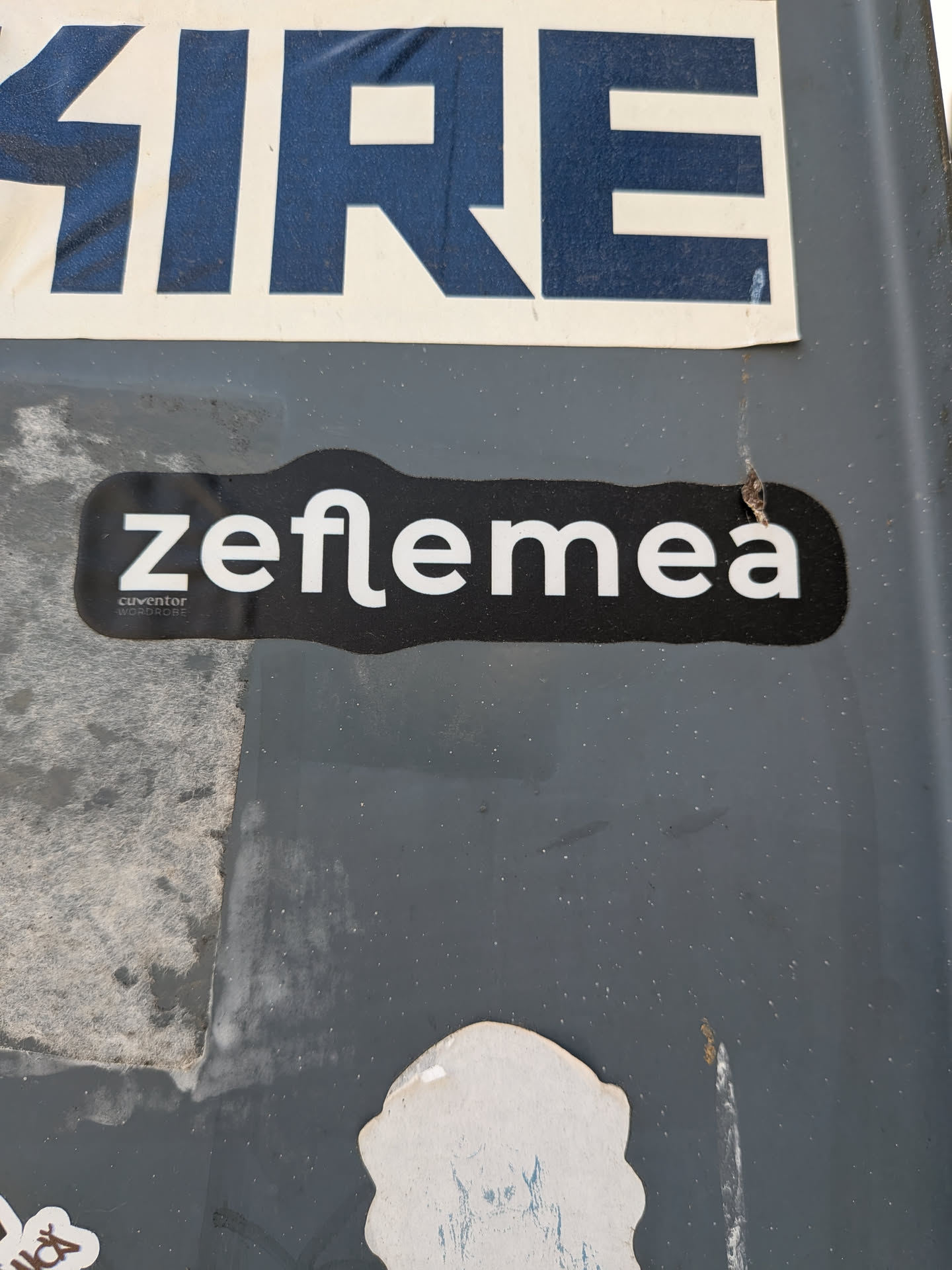 A black die-cut sticker featuring the white stylized text 'zeflemea'. Below the 'z', smaller text reads 'cuvântor' and 'WORDROBE'.