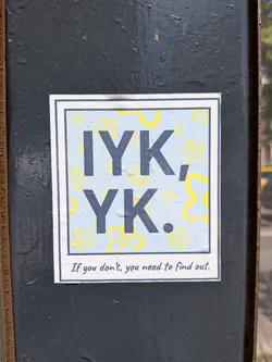 Street sticker A square sticker designed like a Polaroid photo. The central image has a light blue background patterned with yellow outline flowers. Large, dark grey letters spell 'IYK, YK.' across the center. The bottom white border features the handwritten text, 'If you don't, you need to find out.'