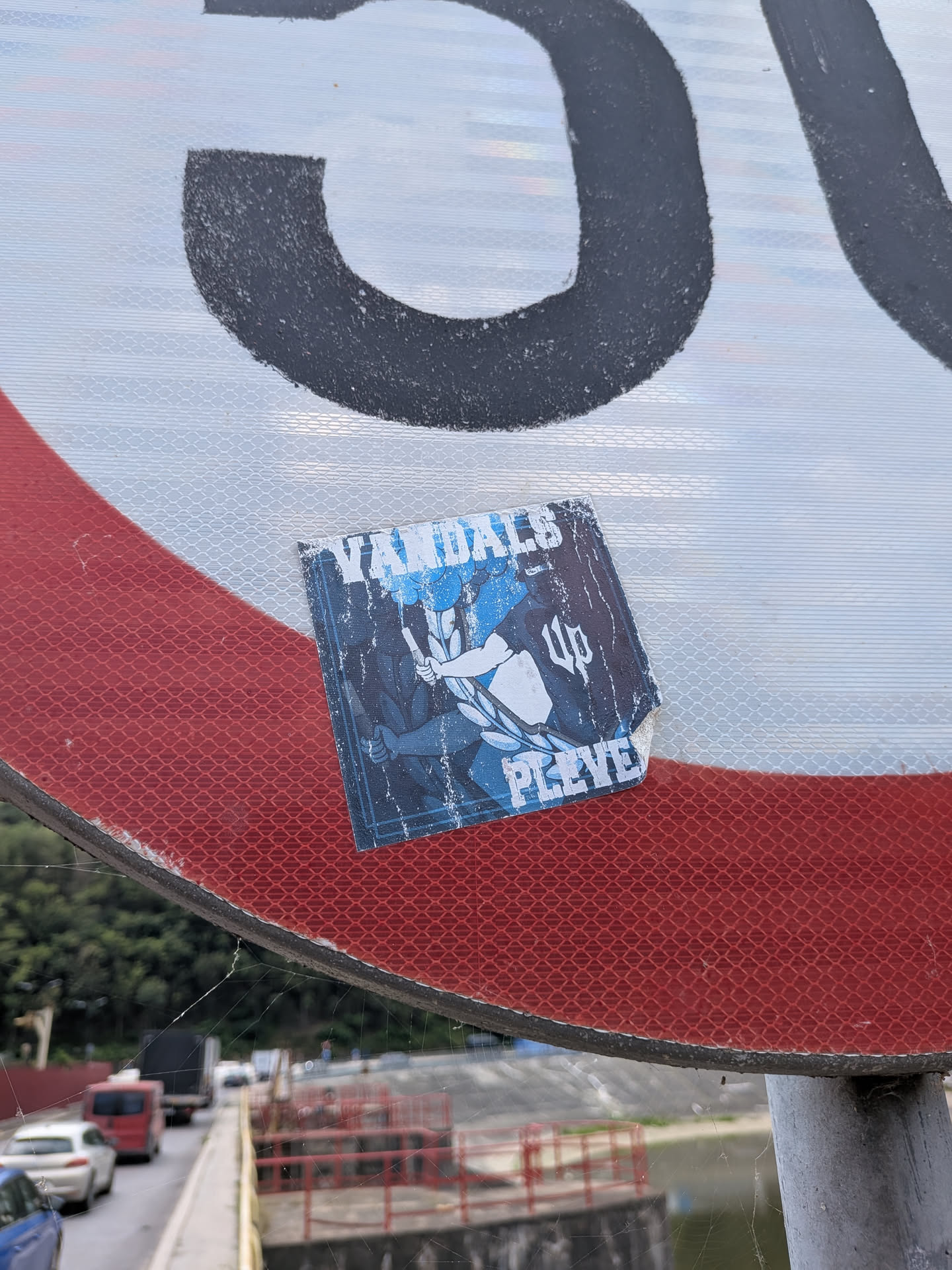 A square, weathered blue and white sticker featuring a central graphic of a figure holding a flare. It displays the text 'VANDALS' at the top, 'UP' in gothic script on the right, and 'PLEVEN' at the bottom.
