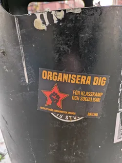 Street sticker A sticker with a red star and a clenched fist, promoting class struggle and socialism. The text is in Swedish.  It includes the name of an organization: Revolutionär Kommunistisk Ungdom (Revolutionary Communist Youth).