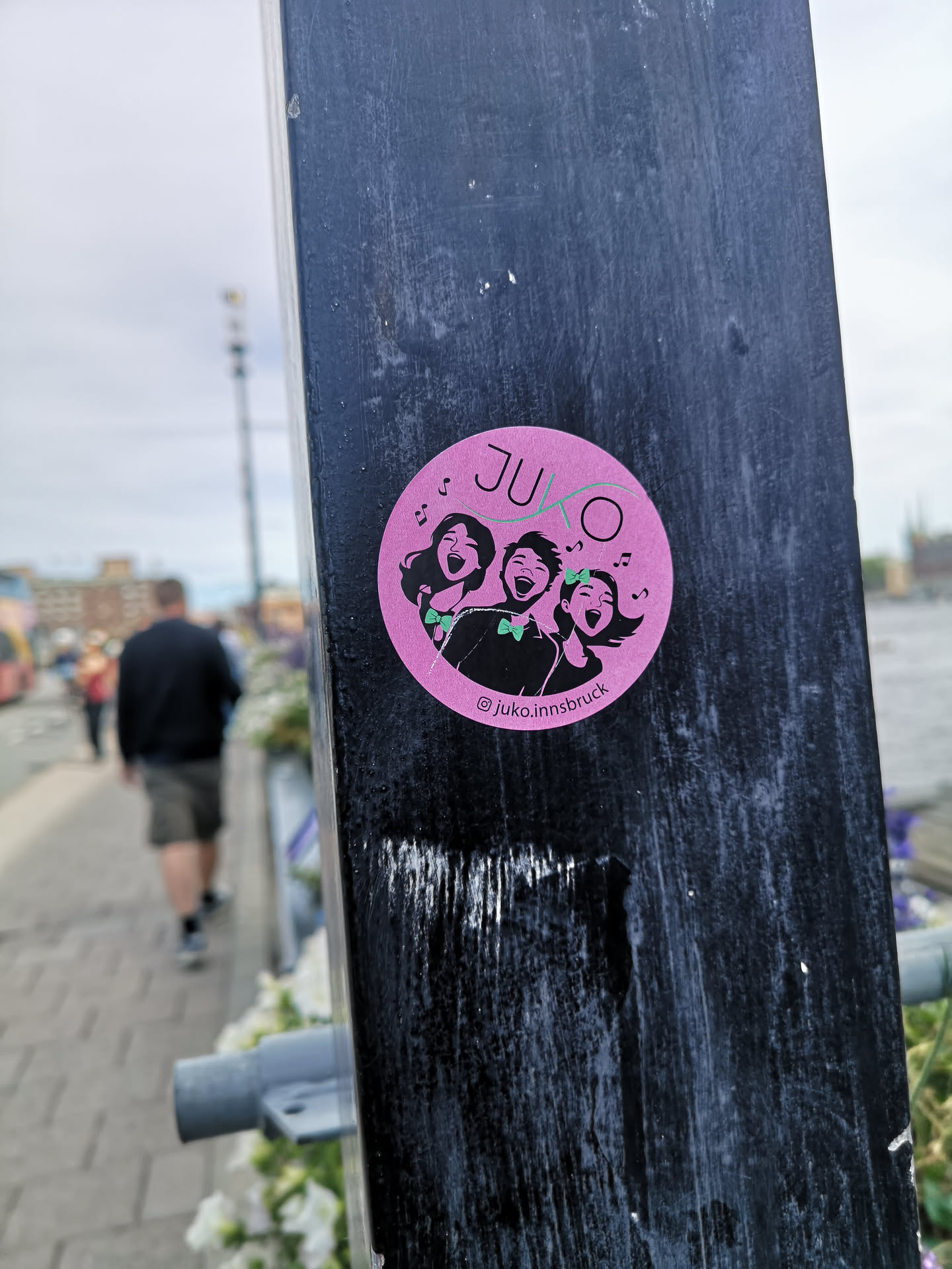 A round pink sticker depicting three stylized singing figures with green bow ties. Features the text 'JUKO' at the top and the Instagram handle '@juko.innsbruck' at the bottom.