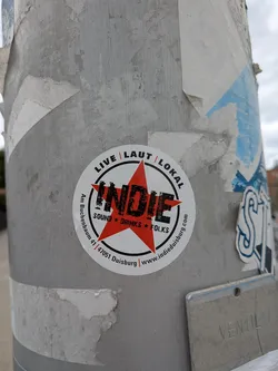 Street sticker Circular white sticker featuring a central red star overlaid with the word 'INDIE' in distressed black font, surrounded by address and website details.