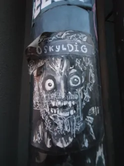 Street sticker Black and white sticker featuring a frightening creature with large eyes and sharp teeth. The word "OSKYLDIG" is visible at the top of the sticker. The artwork style is reminiscent of horror or dark fantasy illustrations.