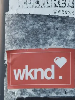 Street sticker A red rectangular sticker with the text "wknd." in white and a pixelated white heart next to it.