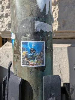 Street sticker This sticker shows a scuba diver swimming underwater among coral reefs. The text "God ton" and "Arsta Skivakademi" are also printed on the sticker.